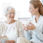 Two women smiling over books and coffee