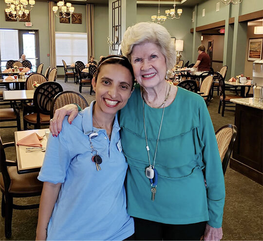 Heartis staff member with a female resident in the dining room
