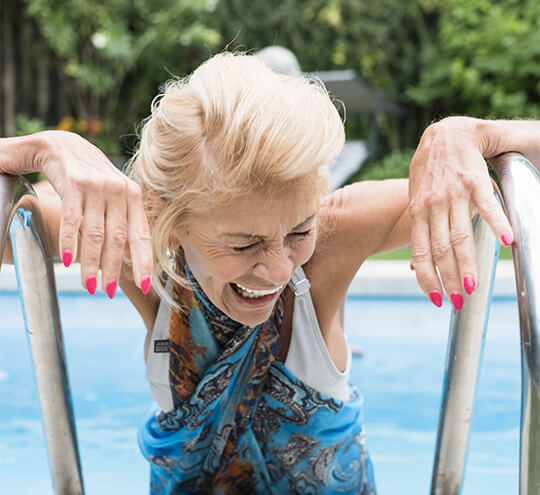 Senior laughing as she steps out of the swimming pool