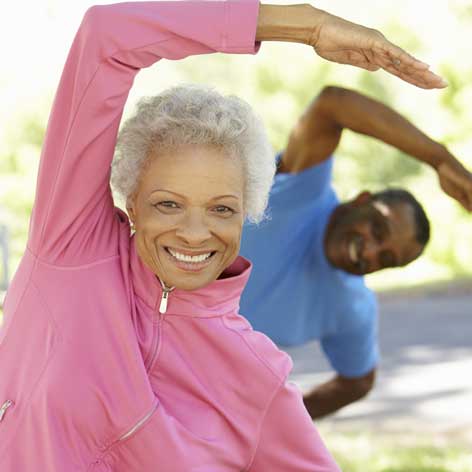 Bucks County Senior man and woman with one arm over their heads doing and excercise