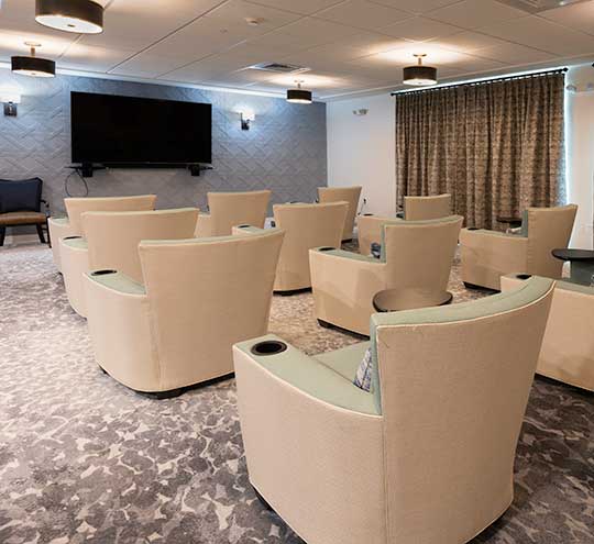 Heartis Venice theatre room with media chairs and flat screen tv